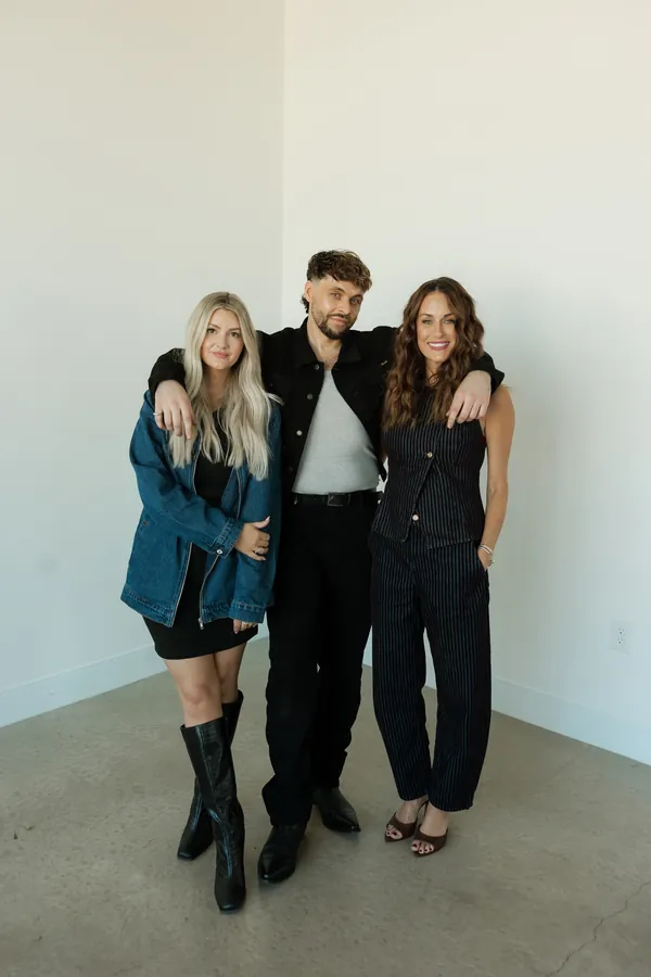 Three stylists posing arm in arm
