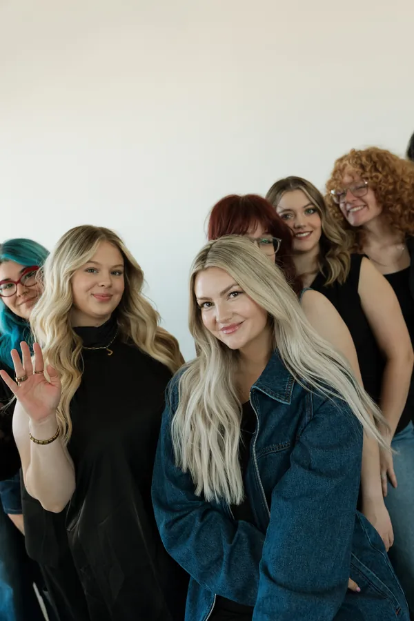 Stylists smiling and waving in a close group